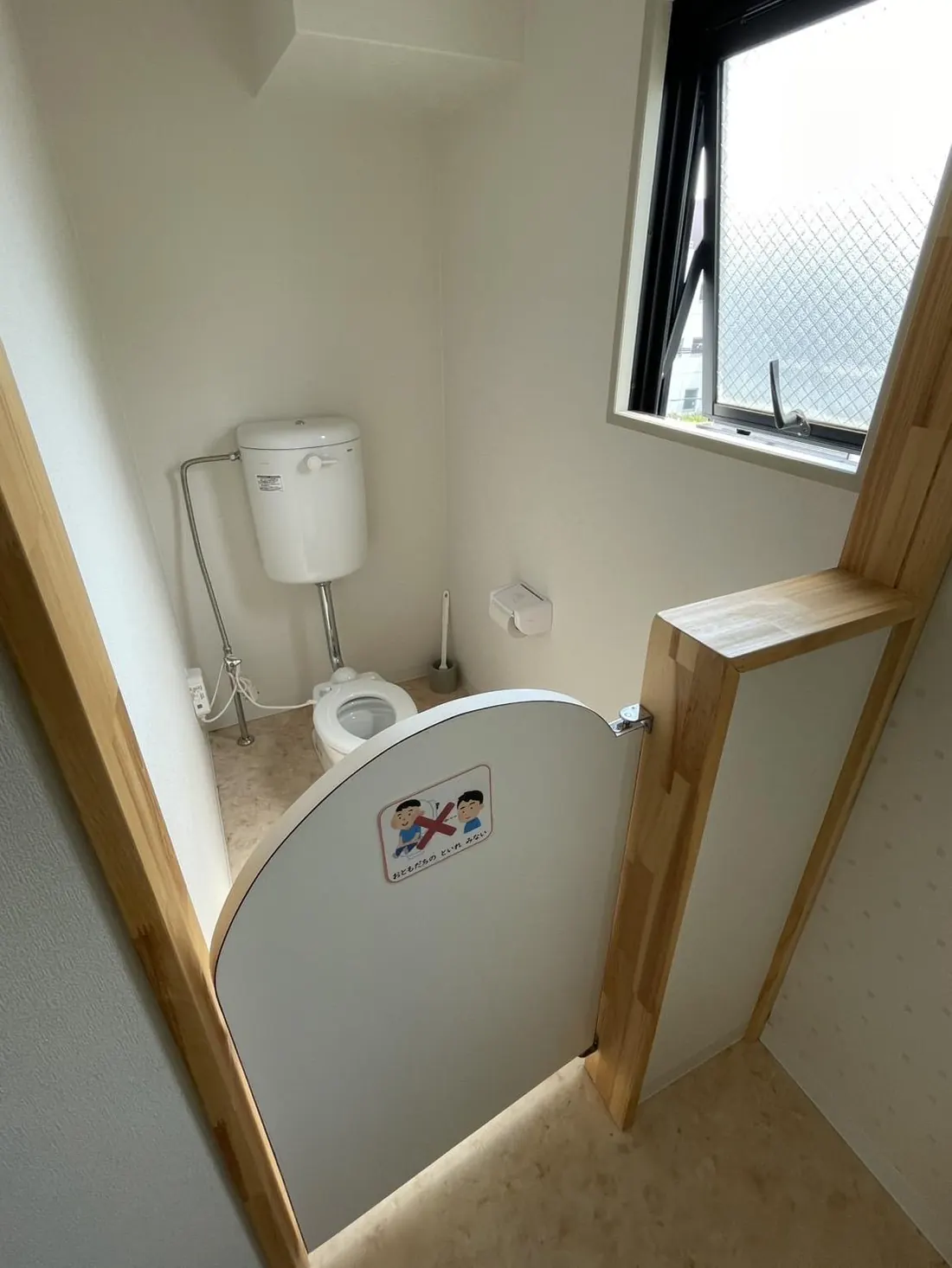 子どもの背丈に合わせた低い扉がついた子ども用トイレの入口