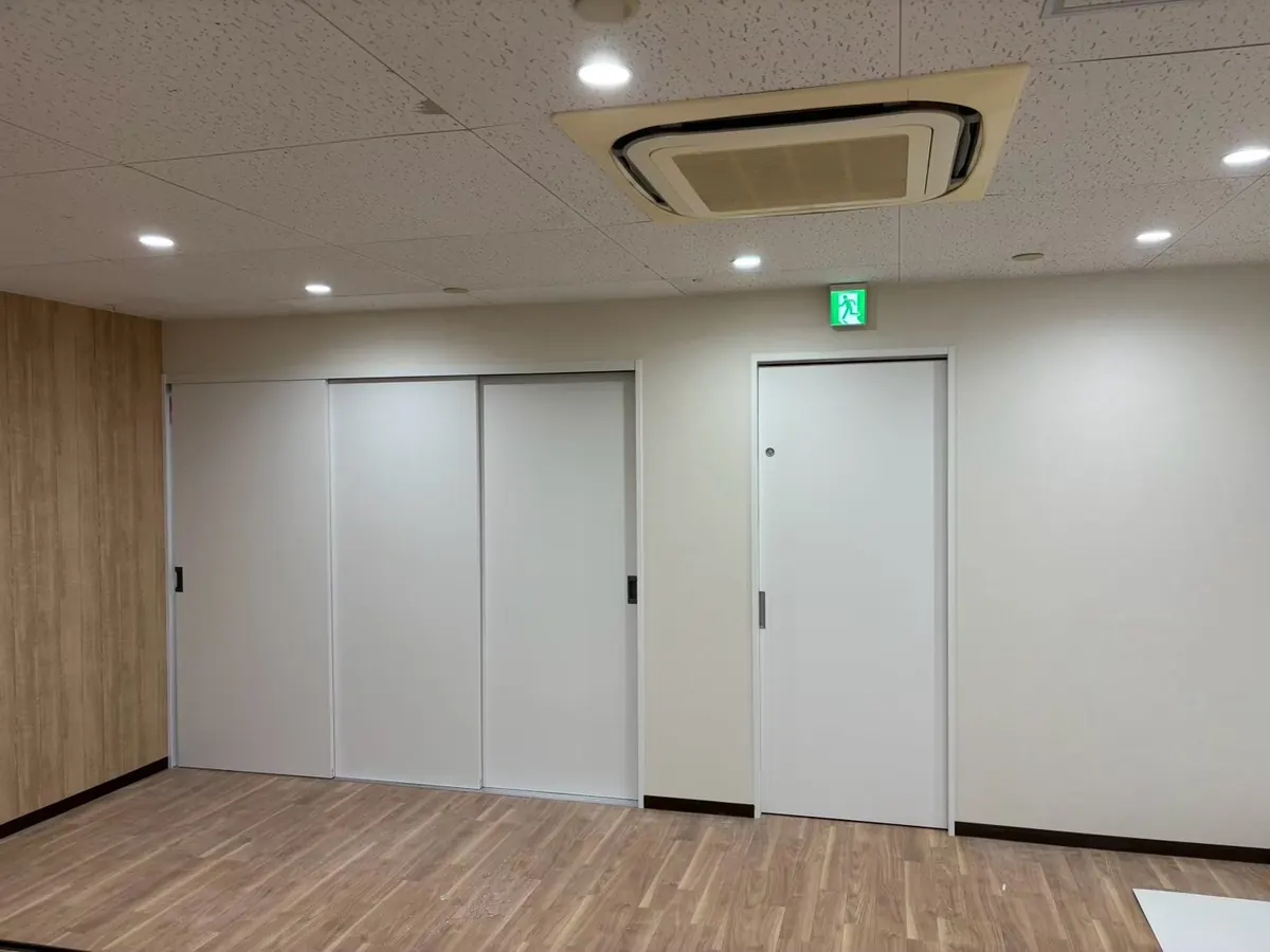 木目の床とアコーディオンの間仕切りがある広いホール